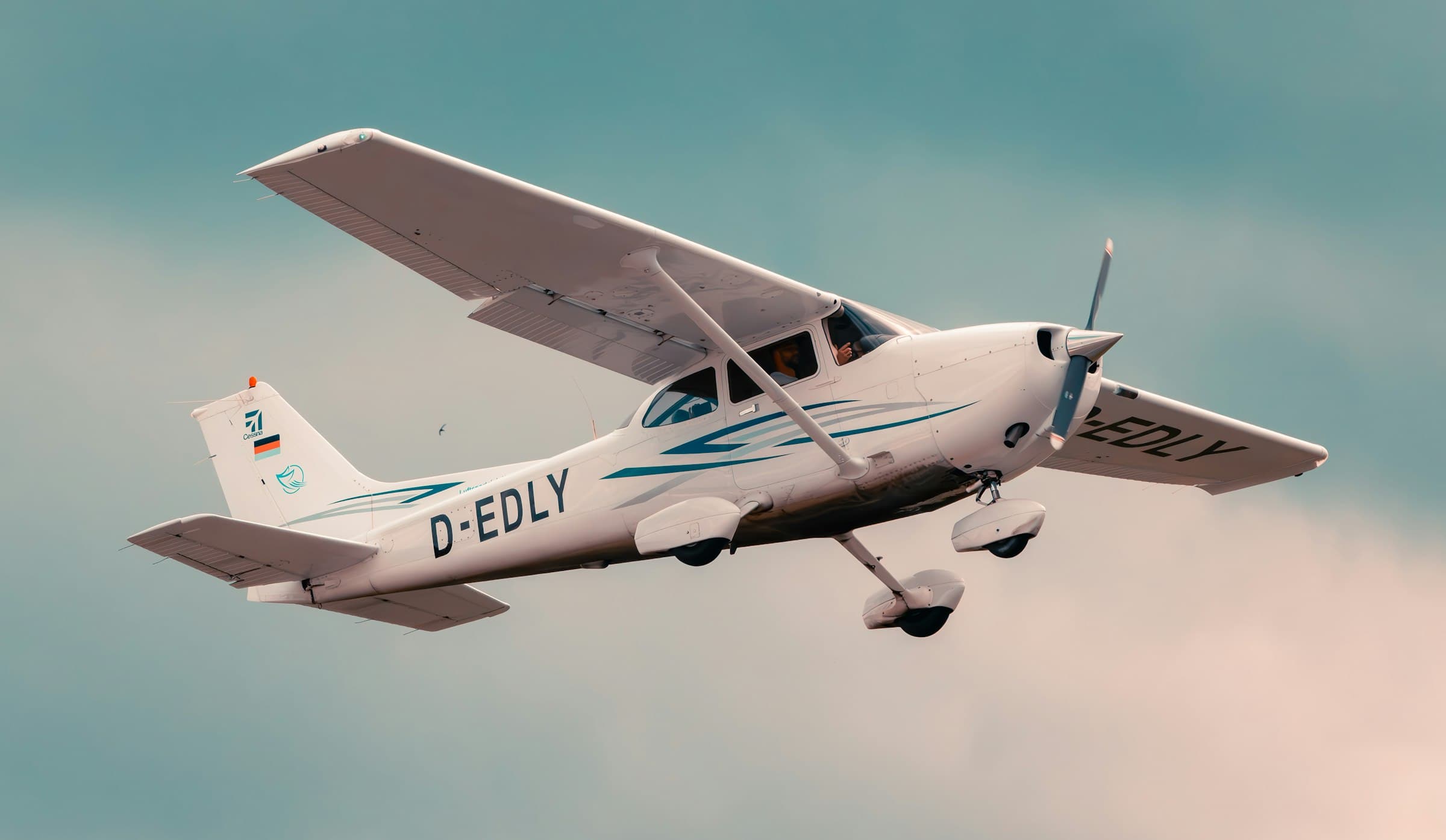 A Cessna 172 single-engine aircraft banking through a bright sky